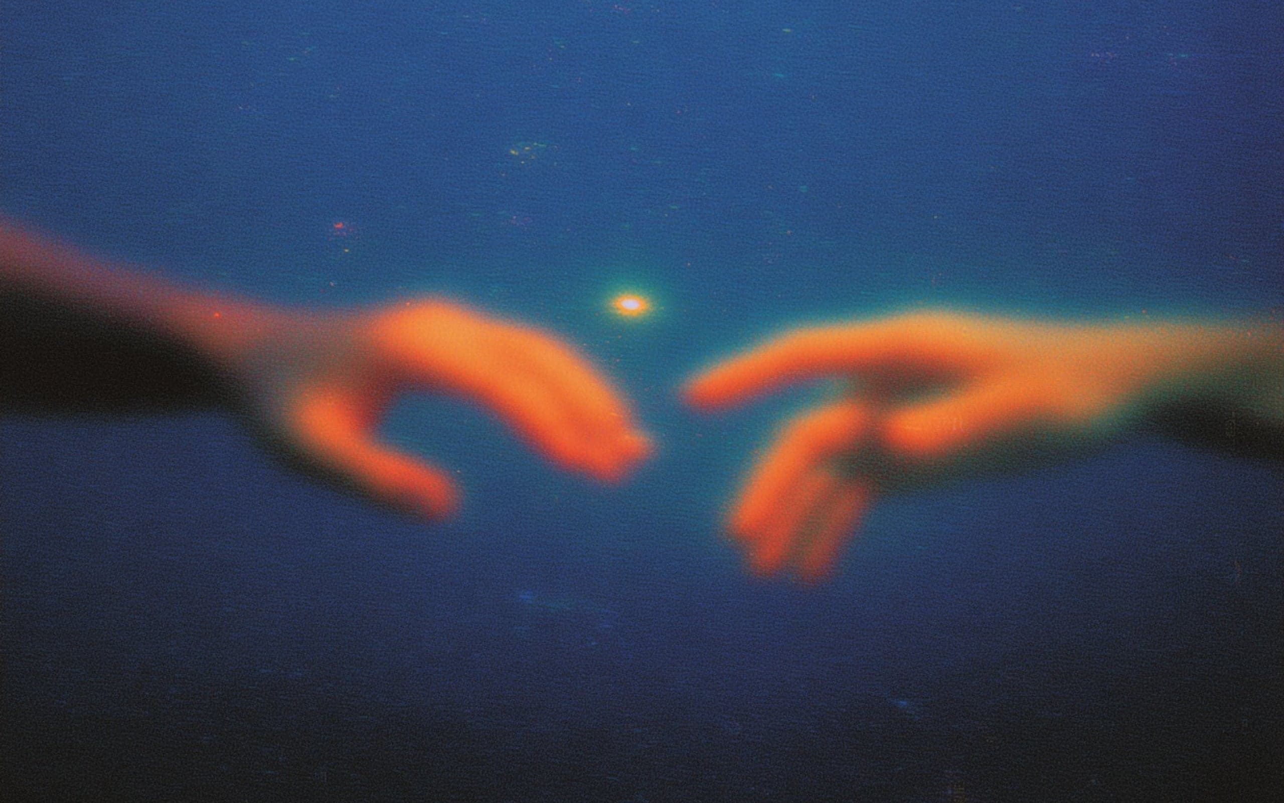 Two glowing hands reaching toward each other over dark water