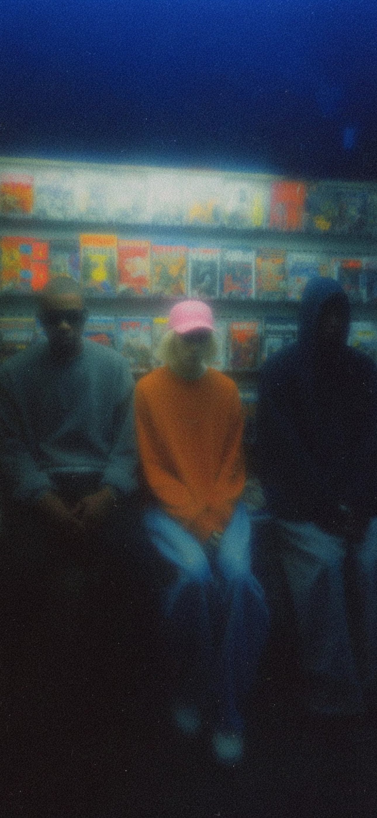 Three friends sitting together in a shop at night